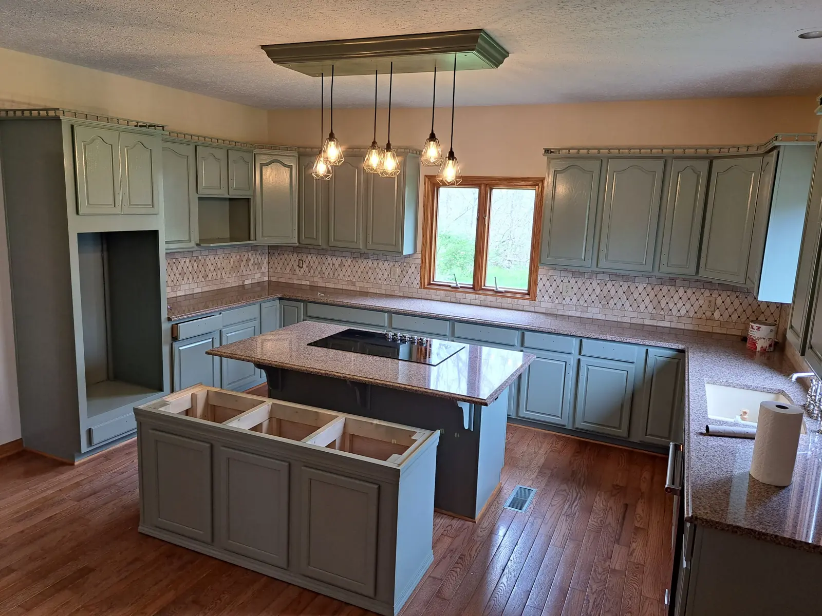 Sage green refinished kitchen cabinets with island by Parks Painting
