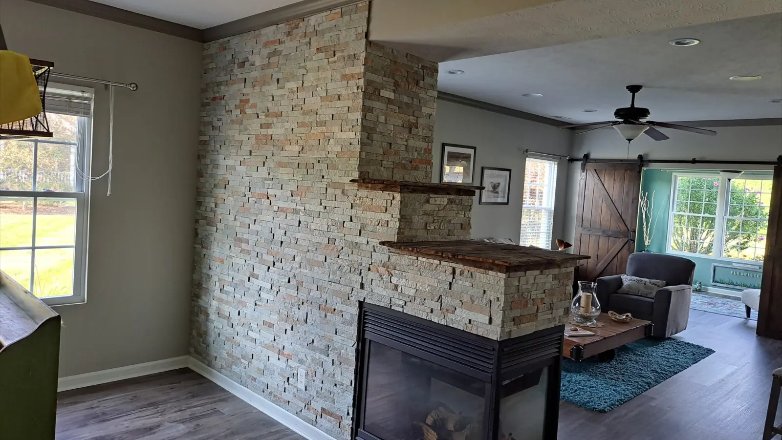 After: Great room walls repainted gray around a stone fireplace in Avon, IN