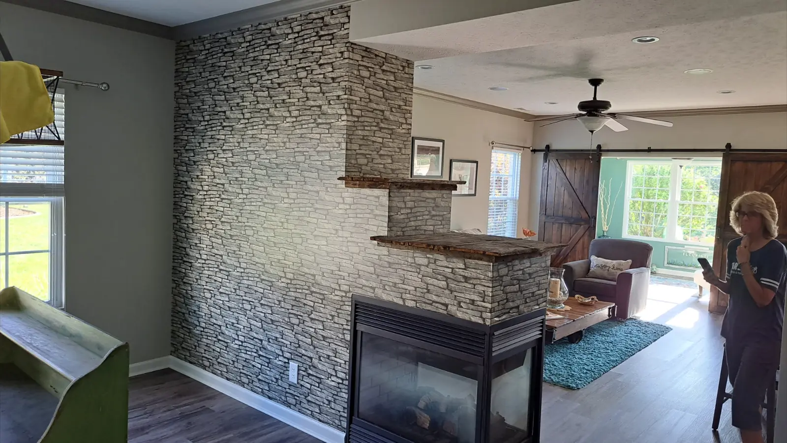 Before: Great room walls repainted gray around a stone fireplace in Avon, IN