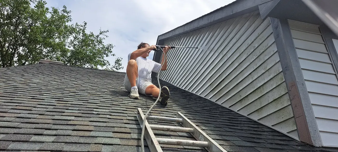 Soft washing house siding from the roof line in Avon, IN
