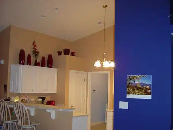 Neutral kitchen walls with a blue accent wall and red accessories in Brownsburg, IN
